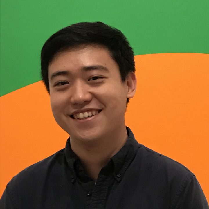 Zidong Zhao smiling in front of a green and orange wall